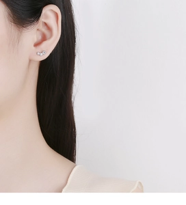 Close-up of 925 sterling silver triple zircon curved stud earring on model ear