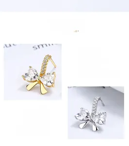 Détails macro des boucles d'oreilles nœud en argent 925 avec cristaux en forme de cœur