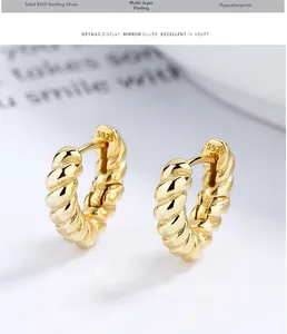 Macro detail of S925 sterling silver stamp on golden twisted rope hoop earrings