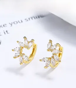 Détail macro de boucles d'oreilles feuilles en argent 925 doré avec zircons marquise