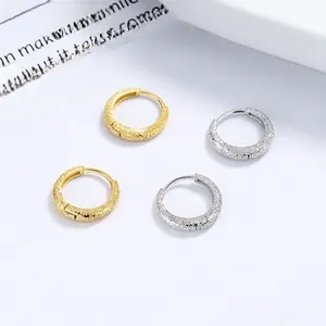 Close-up of frosted 925 sterling silver hoop earrings in gold and silver finish