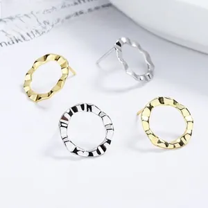 Detailed view of polished gold and silver matte 925 sterling silver wavy stud earrings