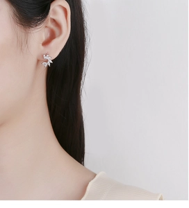 Gros plan de boucles d'oreilles feuilles en argent 925 et oxydes de zirconium sur modèle