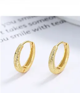 Close-up of gold 925 sterling silver hoop earrings with a matte frosted finish and clasp