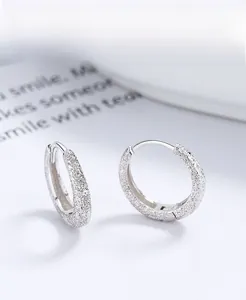 Detailed macro view of minimalist S925 sterling silver hoop earrings with frosted matte finish
