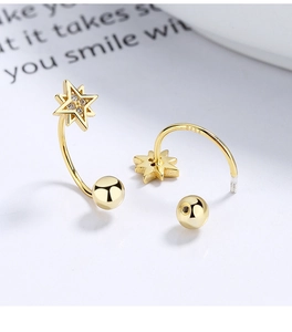 Macro shot of S925 sterling silver star stud earrings with gold plating and zircons