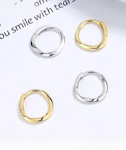 Close-up of gold and silver 925 sterling silver Mobius hoop earrings with twisted design