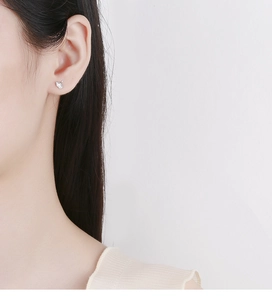 Close-up of elegant 925 sterling silver ginkgo leaf stud earring on a female ear