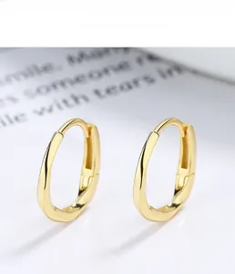 Detailed close-up of golden Mobius hoop earrings made of s925 sterling silver material