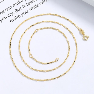 Collana minimalista in argento 999 placcato oro con chiusura a molla su carta bianca