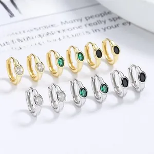 Detail of oval gemstone huggie earrings in gold and silver finishes with various stone colors
