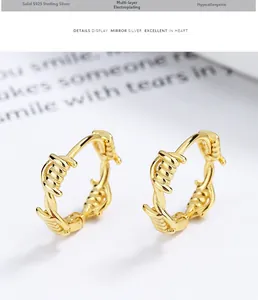 Macro shot of 925 sterling silver hoop earrings with gold-plated thorn wire texture