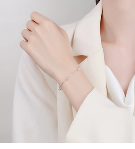 Close-up of minimalist 925 sterling silver bead knot bracelet worn on female wrist