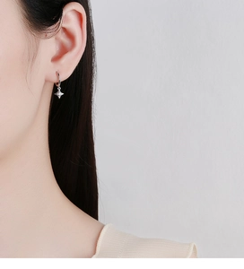 Gros plan sur une boucle d'oreille étoile en argent 925 avec un zircon central brillant