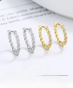 Detailed view of silver and gold twisted rope hoop earrings with micro-pave zircons