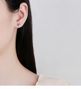 Close-up of minimalist 925 sterling silver butterfly stud earring on female ear