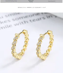 Detailed view of S925 sterling silver gold plated twisted hoop earrings with pave diamonds