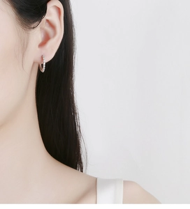 Gros plan de boucles d'oreilles en argent 925 avec zircons blancs sur mannequin