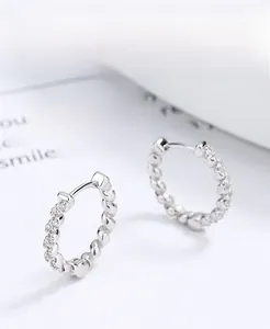 Close-up of twisted 925 sterling silver hoop earrings with shimmering pave-set cubic zirconia