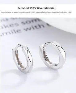 Détail macro de créoles géométriques en argent sterling S925 aux facettes polies