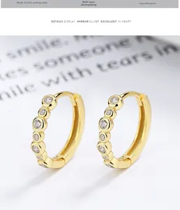 Close-up of gold S925 sterling silver hoop earrings with inlaid round zircons