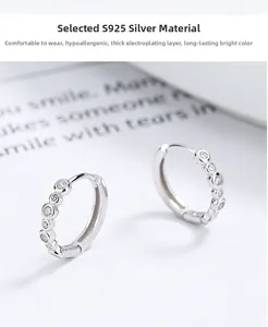 Macro detail of S925 silver hoop earrings with clear cubic zirconia and thick plating