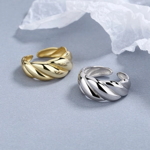 Macro detail of gold and silver croissant rings with polished twisted texture