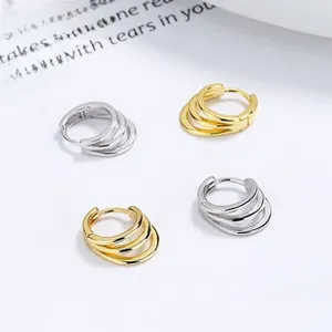 Detail of three-layer sterling silver hoop earrings in gold and silver finishes