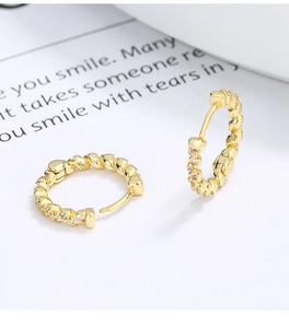 Macro shot of S925 sterling silver twist earrings with gold finish and zircon stones