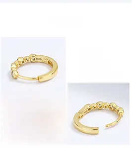 Macro view of gold-plated S925 silver huggie hoop earrings with round bead details