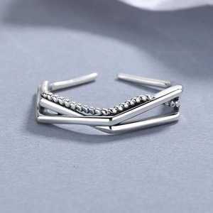 Détail macro de bague croisée en argent 925 avec texture torsadée et couches polies