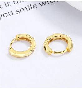 Gros plan du poinçon S925 sur des boucles d'oreilles géométriques en argent doré chic