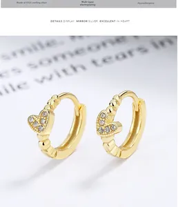 Macro shot of 925 sterling silver heart earrings with gold plating and cubic zirconia