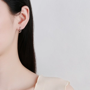 Boucles d'oreilles cœur minimalistes en argent sterling 925 portées par un mannequin