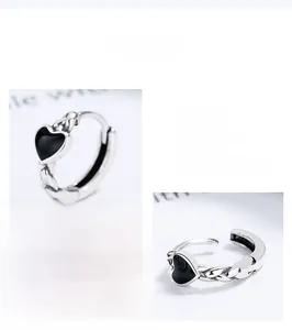 Detailed macro view of 925 silver heart ring with black onyx and twisted texture band