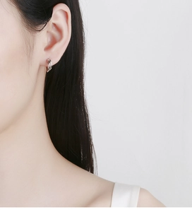 Close-up of triple-layered silver hoop earrings worn by a model for a minimalist look