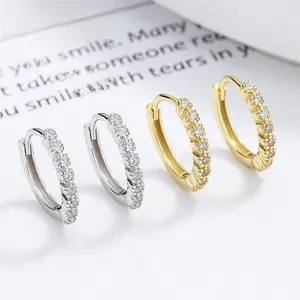 Macro shot of silver and gold plated 925 silver hoop earrings with white zircon accents