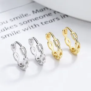 Close-up of minimalist gold and silver link hoop earrings with high-polish finish
