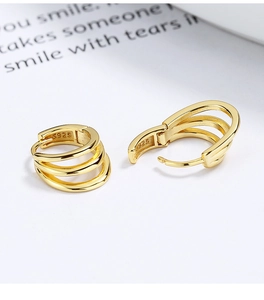 Detailed close-up of S925 sterling silver stamp on golden triple-layer hoop earrings