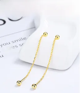 Detailed macro shot of 925 sterling silver gold plated threader earrings with beads