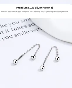 Macro shot of 925 sterling silver threader earrings with polished round beads and fine chains