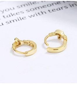 Macro view of gold-plated 925 silver hoop earrings featuring S925 hallmark and texture