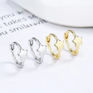 Détail macro de boucles d'oreilles créoles étoile en argent 925 doré et argenté