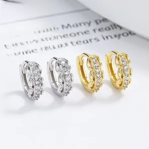 Detailed macro view of 925 silver link huggie earrings with white zircon in gold and silver