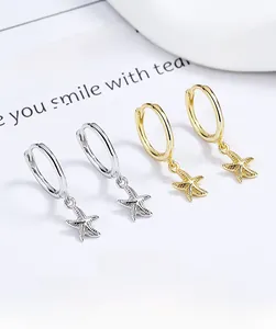 Detailed view of silver and gold starfish charm hoop earrings on a clean white background