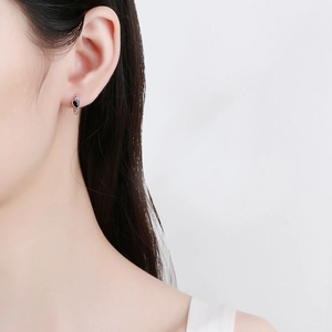 925 silver heart hoop earrings featuring black enamel pendant on a female model