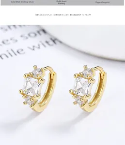 Détail de boucles d'oreilles créoles en argent 925 avec zircon carré doré