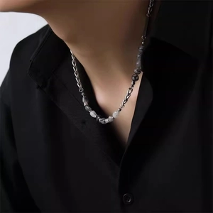 Detail of silver titanium necklace with ice-cracked stone beads on male model