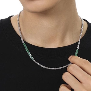 Close-up of silver chain necklace with emerald green zircon stones on a model