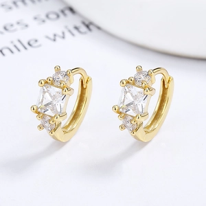 Boucles d'oreilles dormeuses en argent 925 doré avec zircons carrés sur fond blanc